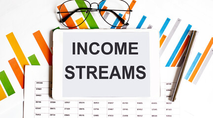 The tablet with tex tincome streams on the business charts and pen