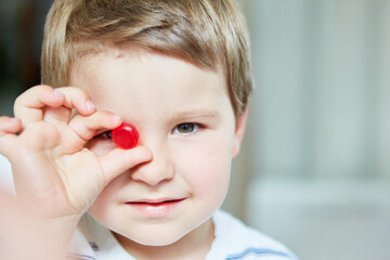 Boy holds a red candy in one hand
