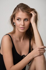 Obraz premium beautiful slender blonde girl in black lingerie posing in the studio
