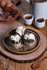 Bolu kukus or steamed cupcake, an Indonesian traditional sweet snack, served in brown plate on wooden table. 