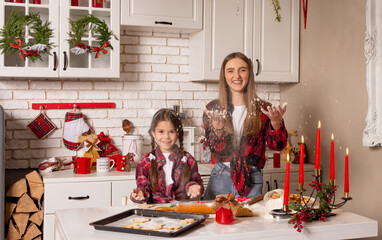 Christmas cookies. Kitchen on Christmas eve. Two sisters make Christmas cookies and have fun playing flour .