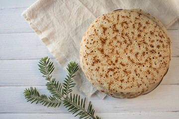 .Food background. Delicious pancakes close-up and a fir branch on a white wooden background. Flat lay, place for text.
