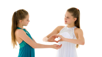 Two adorable girls gymnasts folded palms in the shape of a heart