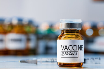 Covid-19 vaccine bottle with a syringe on lab table