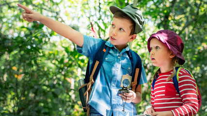 Fototapeta premium Two cute kids trekking in the forest
