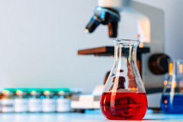 Medical vial with medication near microscope photo