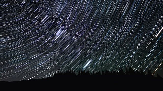Time lapse of Star trails in the night sky over the mountains. 4K