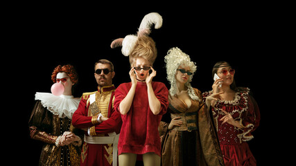 Medieval people as a royalty persons in vintage clothing and modern eyewear using devices on dark...