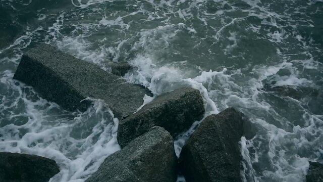 Waves submerging the jagged rocks