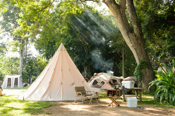 A large white traditional teepee tent with luxurious glamping interiorwith desk and chairs in...