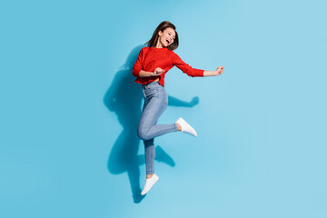 Full size photo of funny lady jump high up rejoicing wear knitted red pullover sneakers jeans...