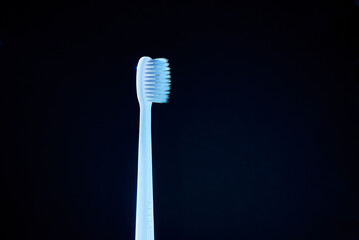 white toothbrush in blue light. dark background
