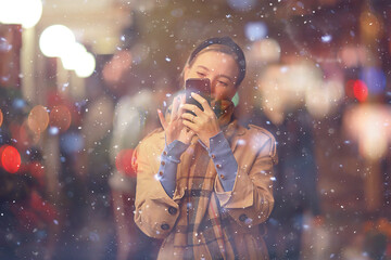 happy girl lights evening christmas shopping standing on the street by the shop window