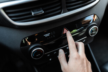 Fototapeta premium Interior view of a modern new car. Car driver pushing the attention alarm button.