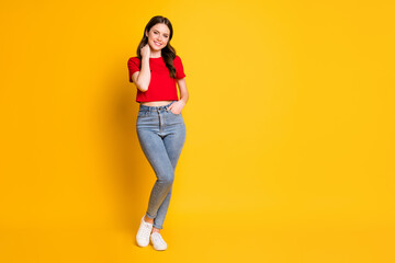 Full length photo of charming lady good mood wear red t-shirt cropped top jeans footwear isolated yellow color background