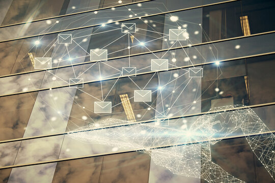 Double exposure of envelop hologram flying from gadget and city view background. Concept e-mail.