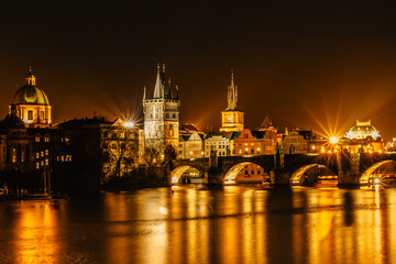 Fototapeta na wymiar Illuminated Charles Bridge,Karluv most reflected in Vltava River. Evening panorama of Prague, Czech Republic. Long exposure city lights.Amazing European cityscape.Travel urban concept