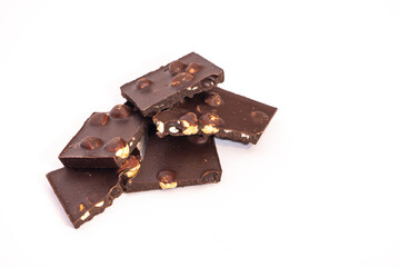 Appetizing pieces of chocolate with a whole nut on a white background