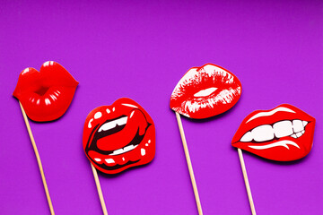 four stencils in the form of women's red juicy sexy lips on a solid purple background