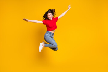 Fototapeta na wymiar Full size photo of cheerful girl jump hold hand isolated over vivid color background