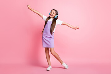 Fototapeta na wymiar Full size photo of excited kid girl listen wireless headset music sing wear violet overall isolated on pastel color background