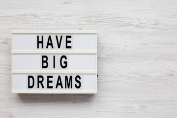 'Have Big Dreams' on a lightbox on a white wooden background, top view. Flat lay, overhead, from above. Copy space.