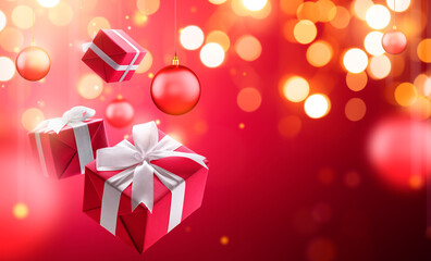 Christmas gifts with hanging bauble over blurred bokeh light background