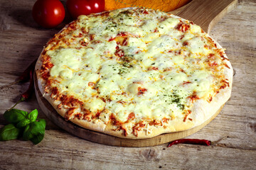 pizza aux fromages sur une table en bois