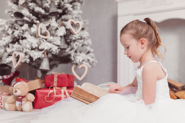 Weihnachten kleines hübschen Mädchen im weißem Kleid Prinzessin liest in einem alten Buch Weihnachtsdekoration Var. 8