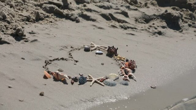 heart symbol of sea shells at sandy beach