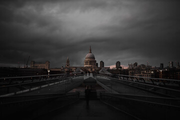 Millennium Bridge with the St Paul Cathedral in the distance below cloudy sky