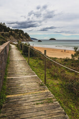 Fototapeta na wymiar Wooden path next to the Laga's beach in Basque Country during a cloudy day