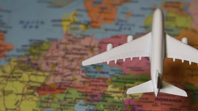 Toy of white plane flying over the Europe map.