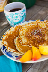 Table setting with breakfast pancakes and sliced peach. Selective focus - shallow depth of field.