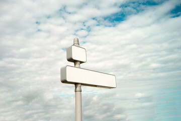 Sign post white on sky with clouds