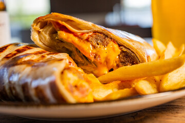 Burrito con polpette di scottona, cheddar, bacon croccante, maionese, insalata e salsa barbecue