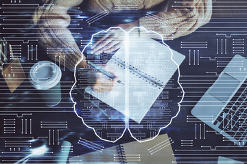 Multi exposure of writing hand on background with brain hologram. Concept of learning.