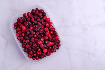 Frozen cranberries in a plastic container