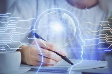 Multi exposure of writing hand on background with brain hologram. Concept of learning.