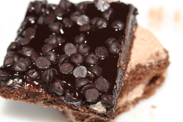 Chocolate and cream made cake and pastry display with selective focus. Close and partial view on white background.