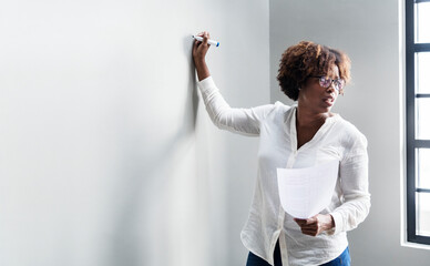 Black woman writing on a whiteboard
