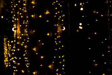 Fototapeta na wymiar Defocused garland lights, Bokeh effect. Sparkling and fairy background. Christmas and New Year holidays concept.