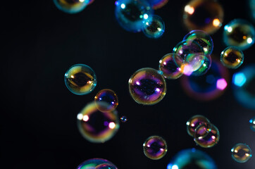 Abstract, Beautiful bokeh, blur fantasy soap bubbles floating in the dark. Black background.