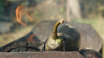 Eggplant on fire with blue flames isolated on fire background