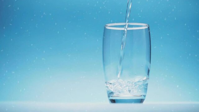 cinemagraph, water is poured into a glass on blue background