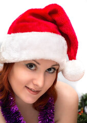 Portrait of beautiful young woman in red santa hat on white background.