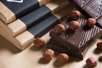 Close-up of homemade chocolate bar with nuts on craft paper background
