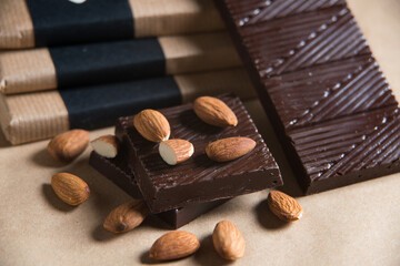 Close-up of homemade chocolate bar with almond on craft paper background