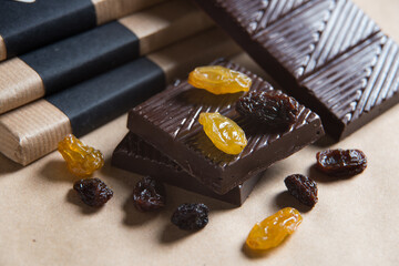 Homemade chocolate bar with raisins on craft paper background