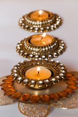 Decorative candles in golden holders, warm festival vibe. Peaceful zen lights.